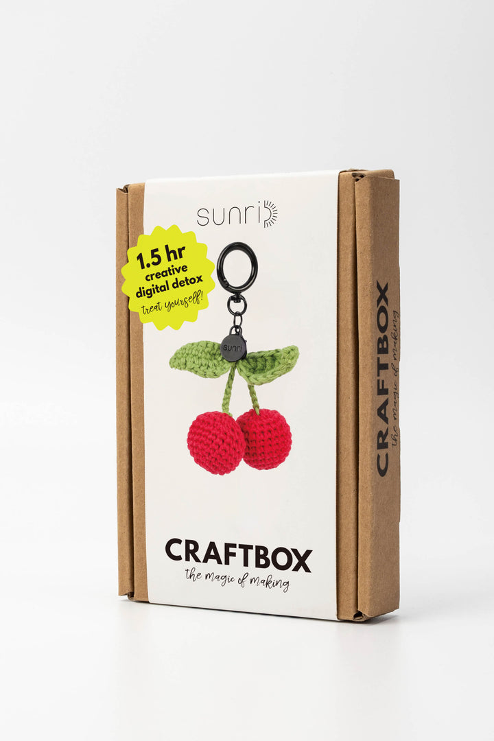 Craft box packaging with cherry keychain design on a white background
