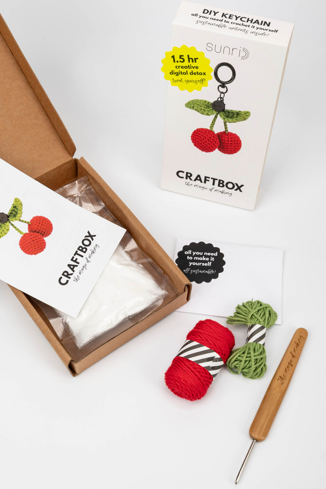 Craft kit with yarn, crochet hook, and packaging on a white background