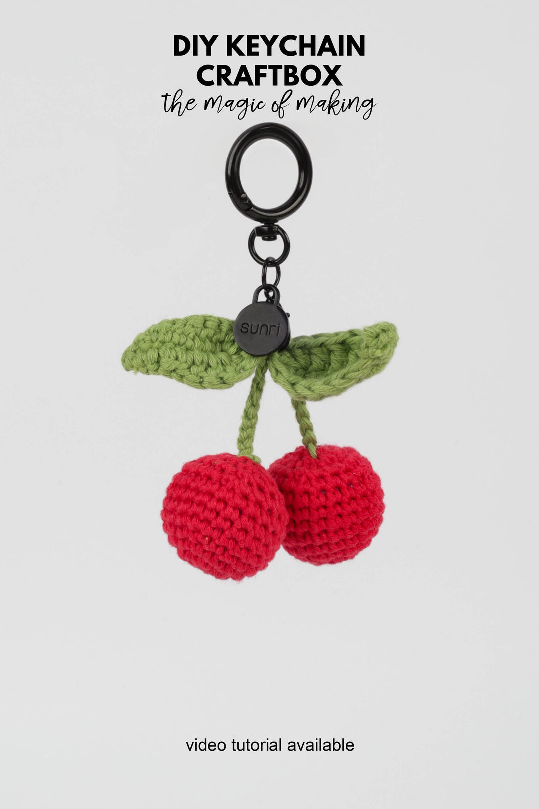 Crocheted cherry keychain with green leaves on a white background, featuring 'DIY Keychain Craftbox' text.