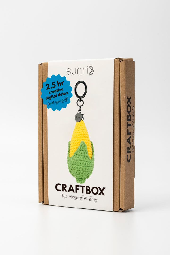 Craft box with a crochet keychain of a corn on the cob and branding details.