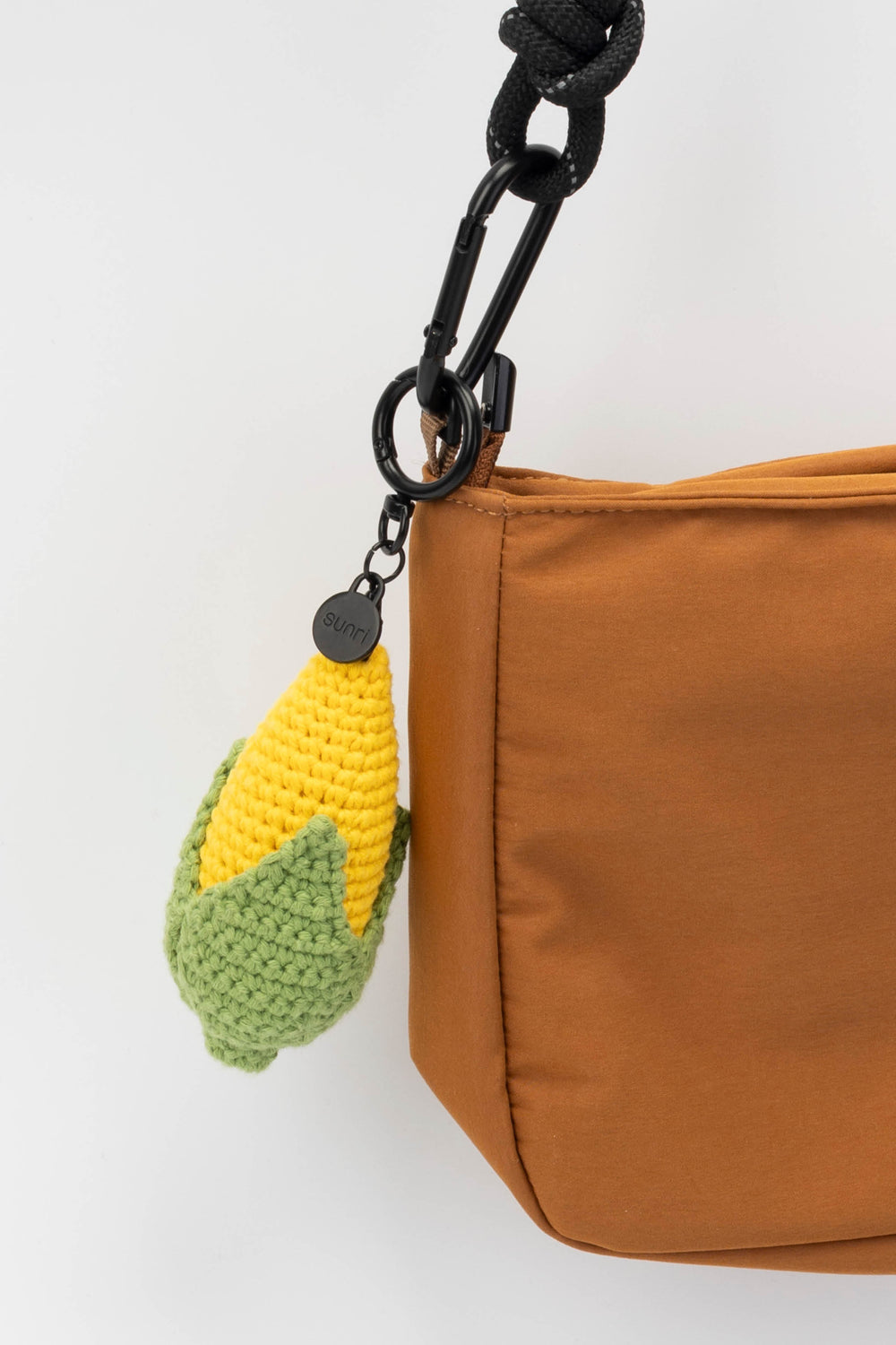 Brown bag with a crochet corn keychain on a white background