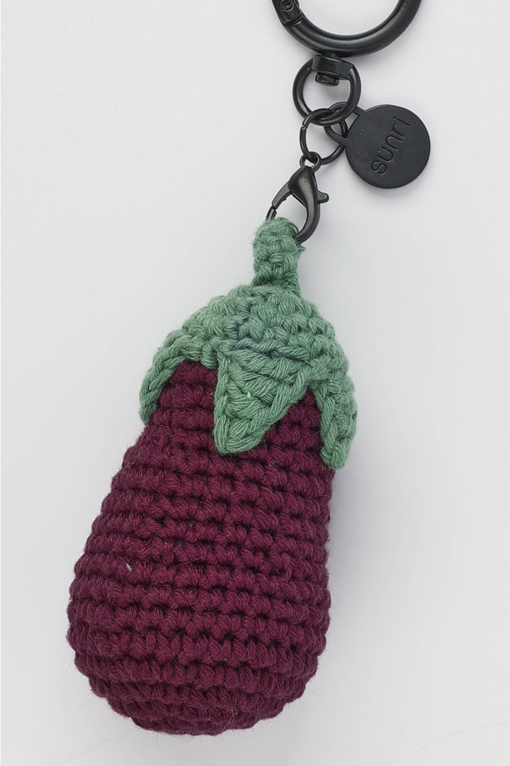 Crocheted eggplant keychain with a green stem on a white background
