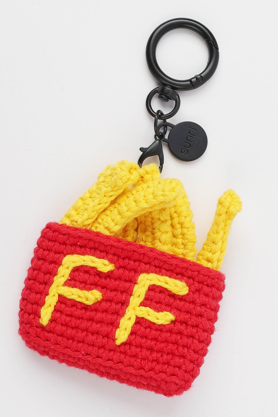 Crocheted French fry keychain with red bag and yellow fries on a white background