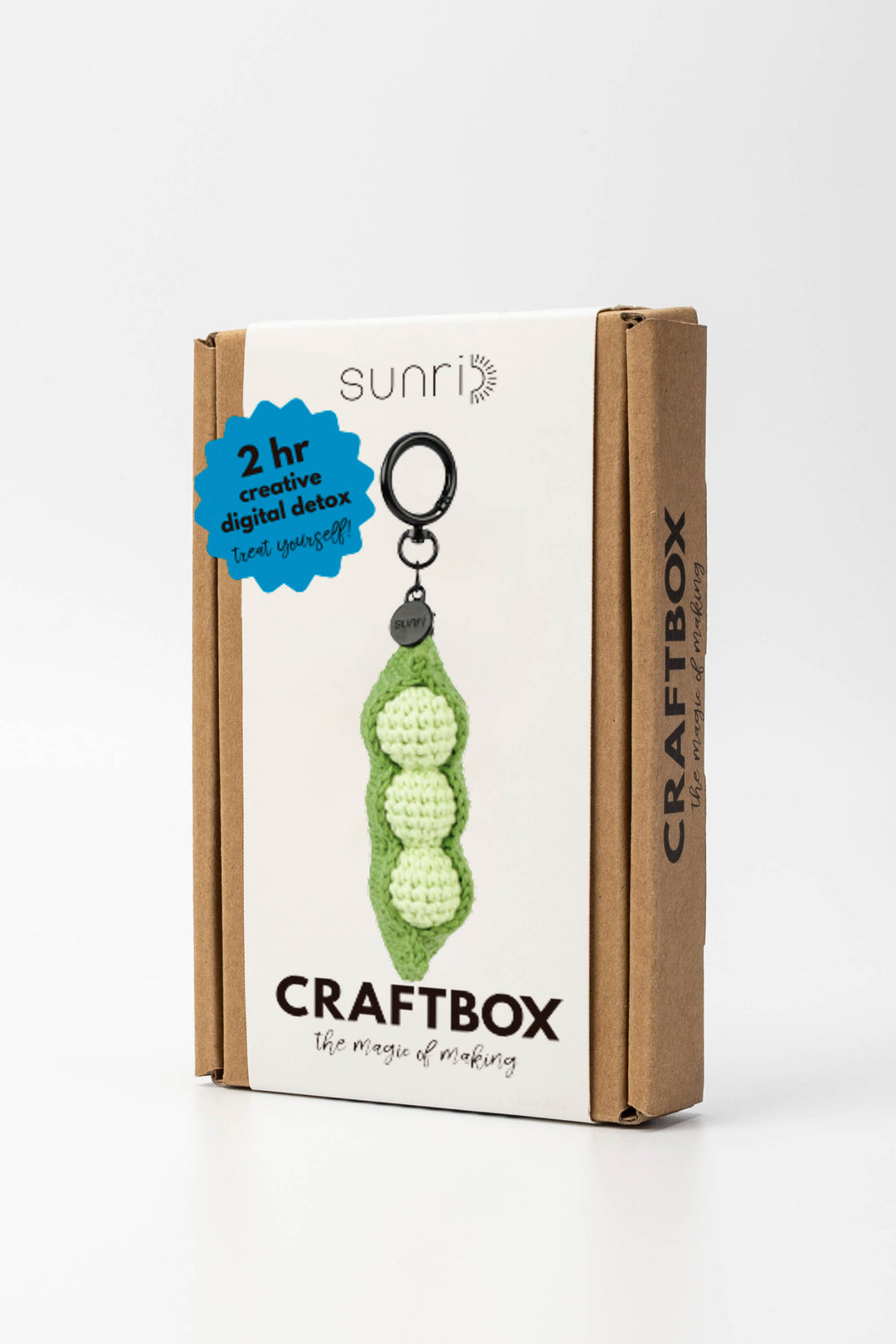 Craft box with a green crochet pea-shaped keychain on a white background