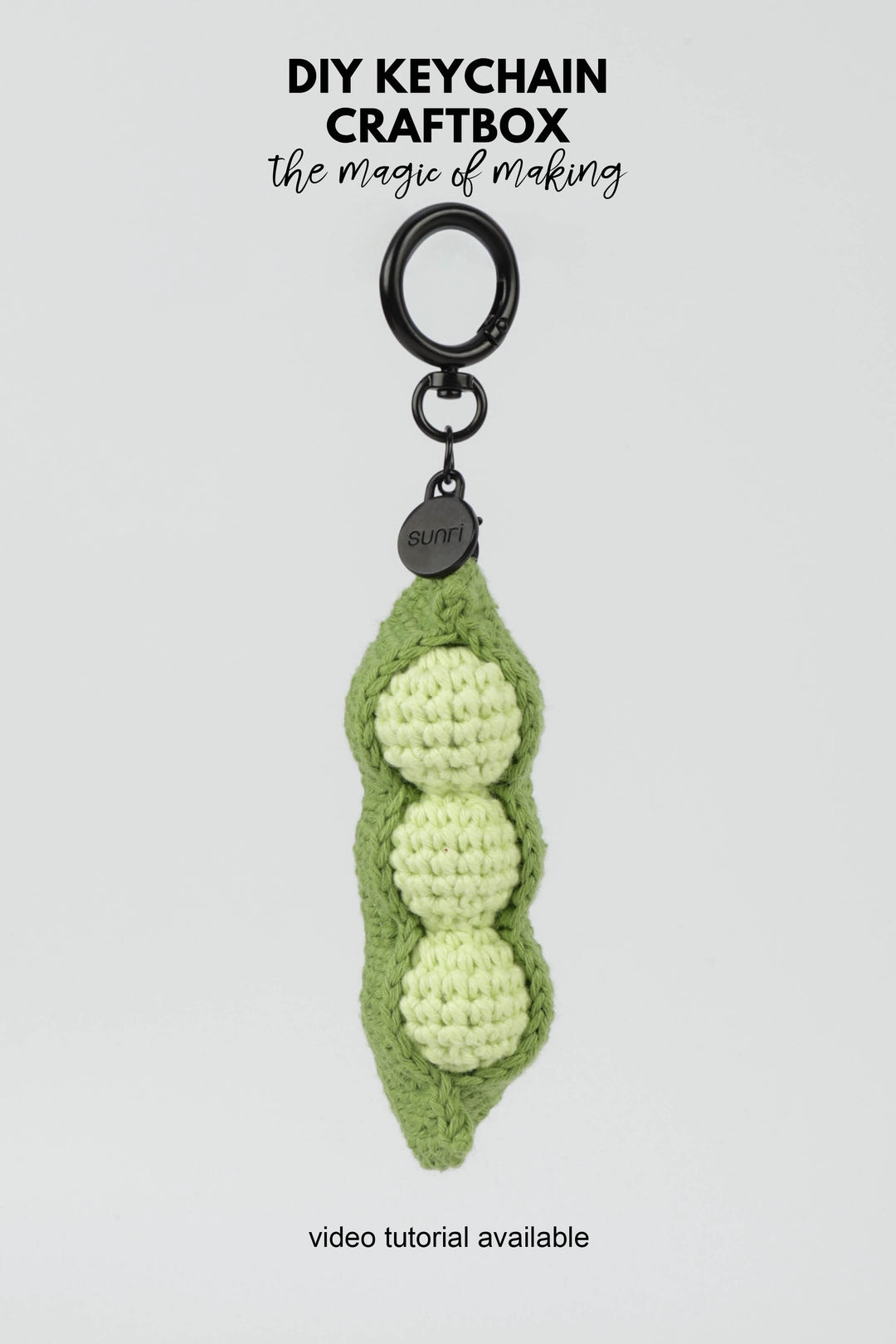 Crocheted green pea pod keychain on a white background with text about DIY keychain craftbox.
