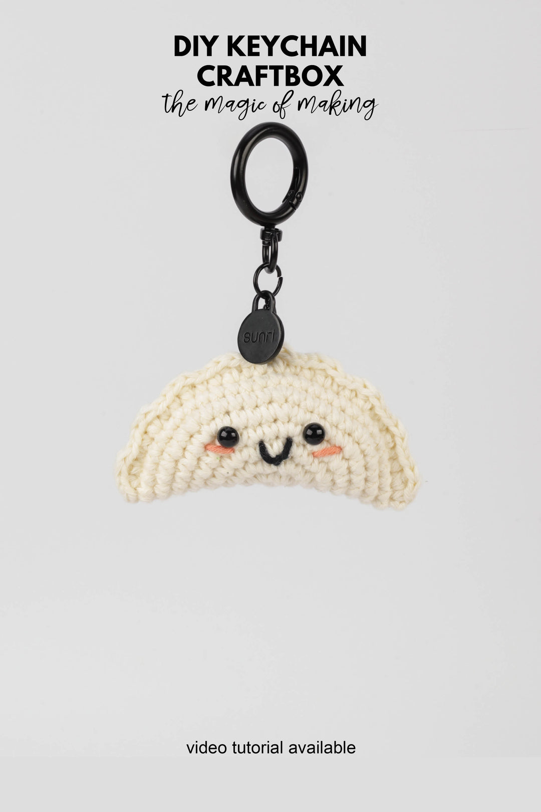 Crocheted keychain with a face on a white background, featuring text about DIY keychain craftbox.