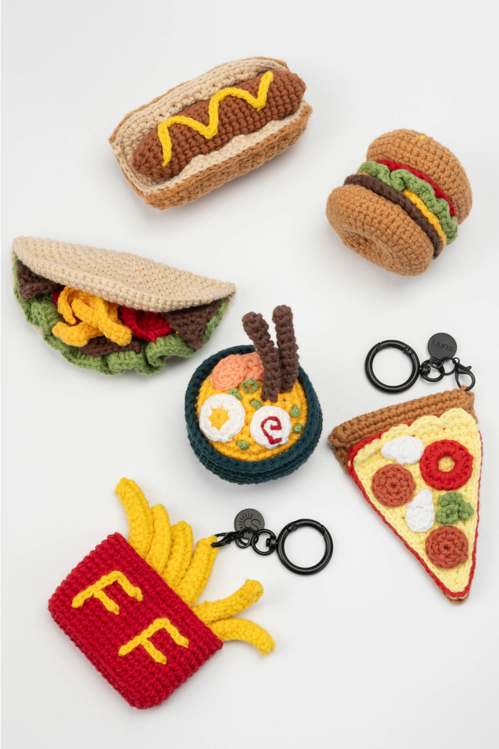 Collection of crocheted food-themed keychains on a white background