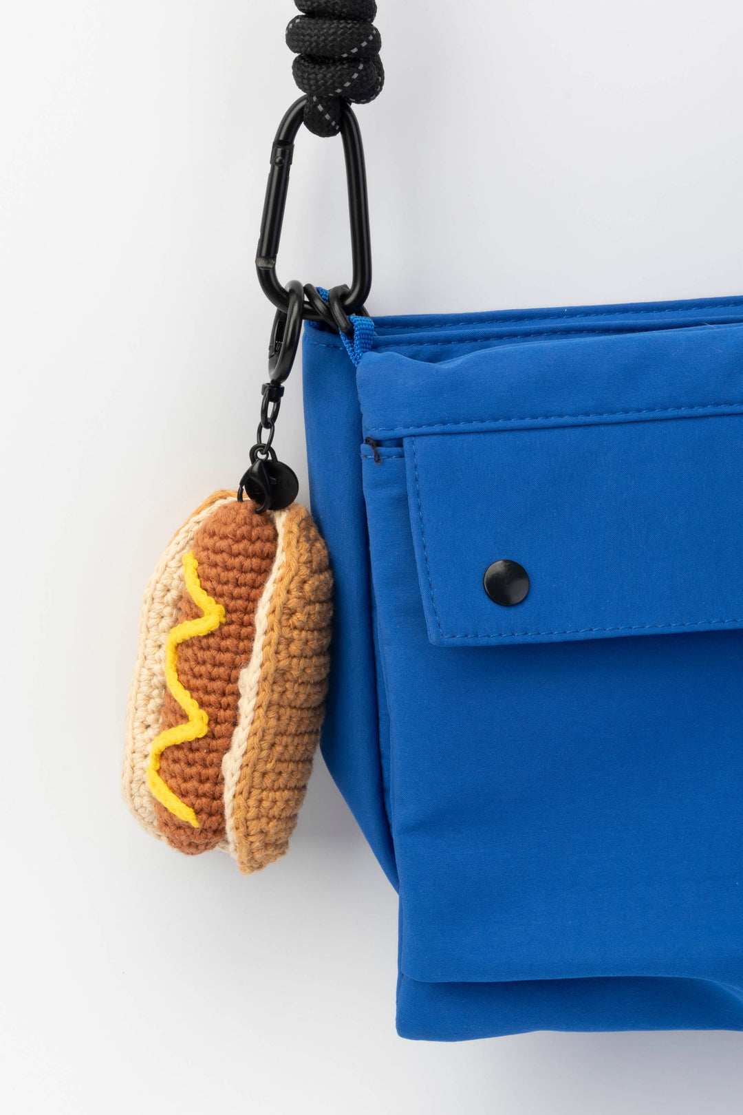 Blue bag with a hot dog-shaped keychain on a white background