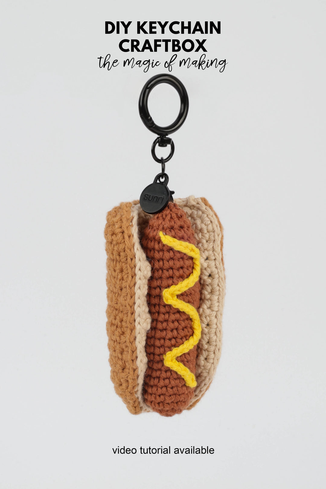 Crocheted hot dog keychain with mustard on a white background, featuring 'DIY Keychain Craftbox' text.