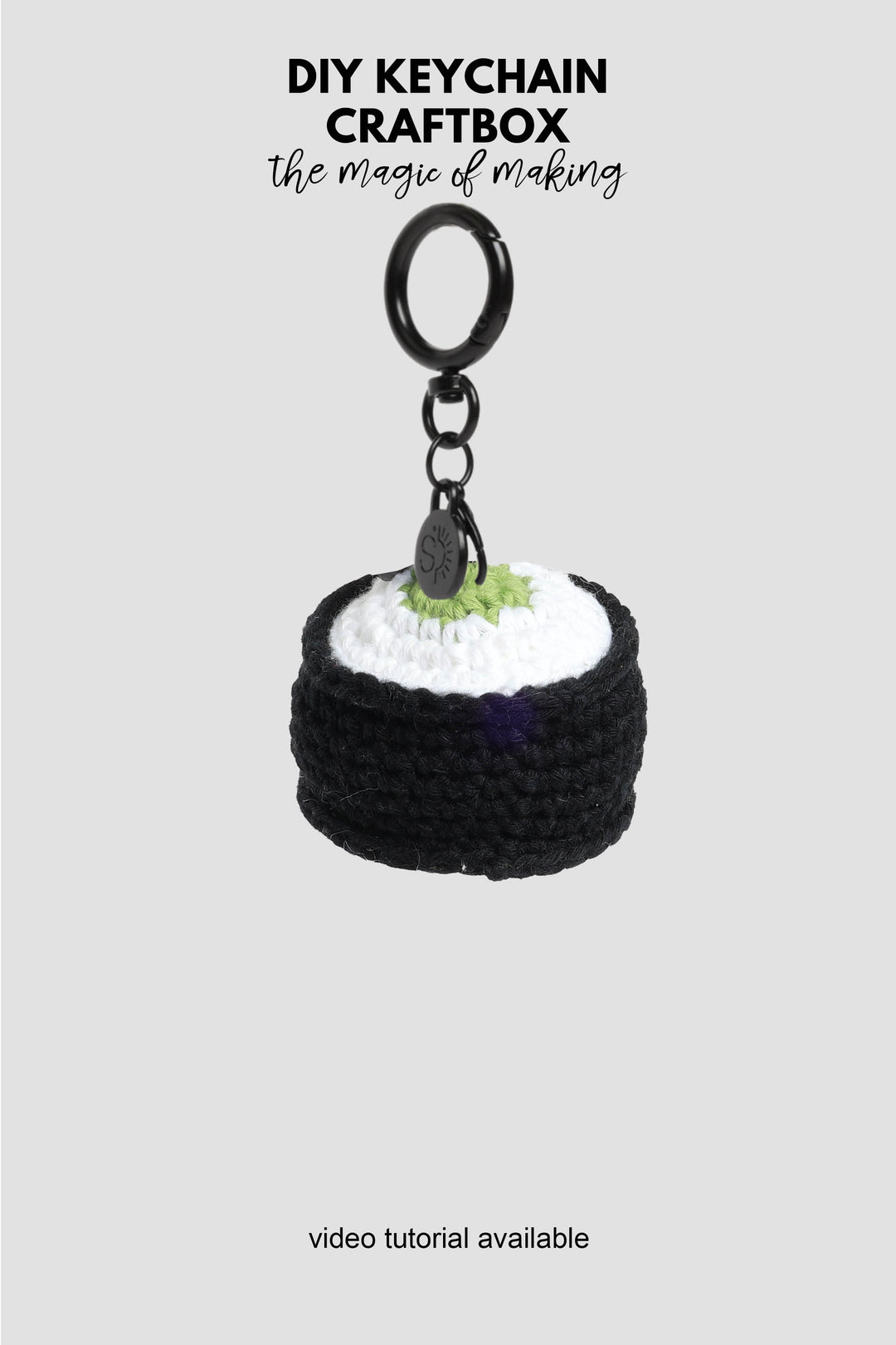 Crocheted sushi keychain with a black ring on a light gray background