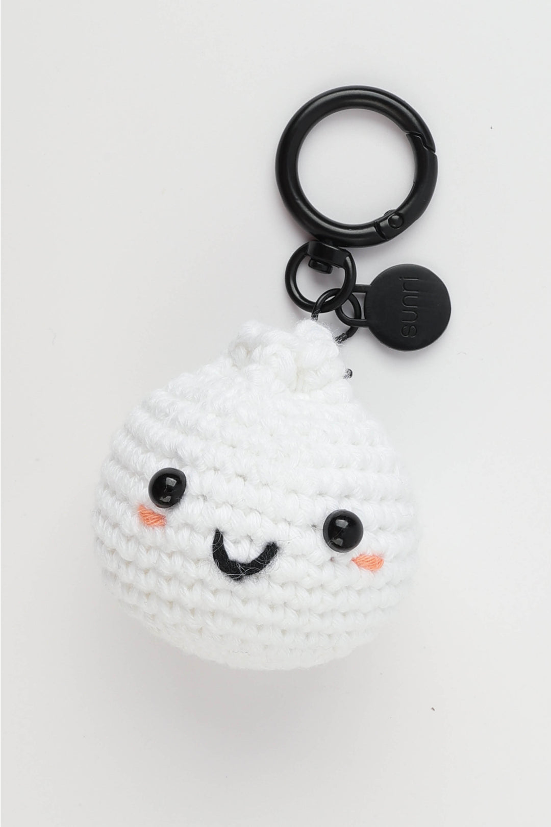 White crochet sushi keychain with black eyes and orange mouth on a white background