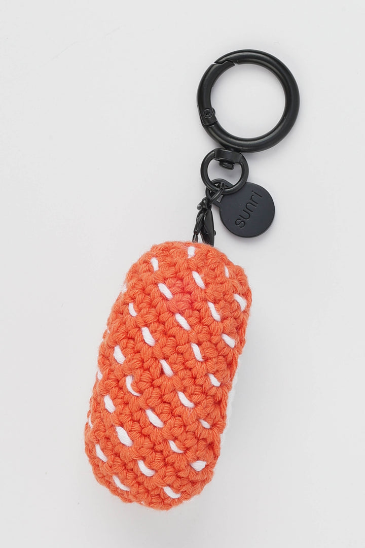 orange sushi shaped crochet keychain with a black ring on a white background