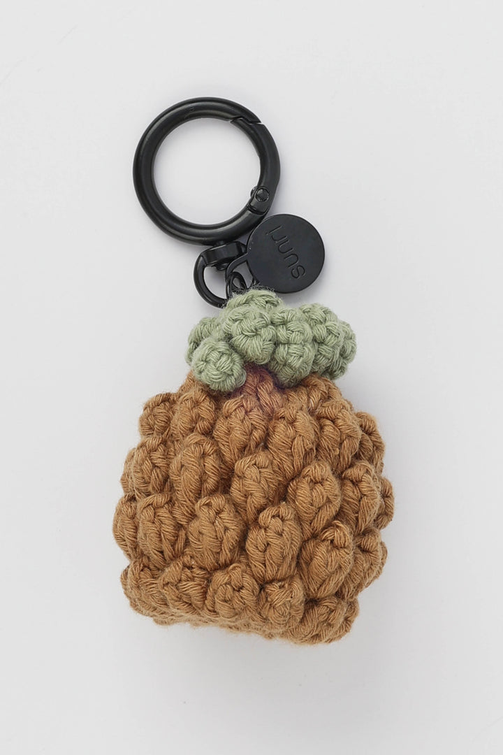 Crocheted pineapple keychain with a black ring on a white background