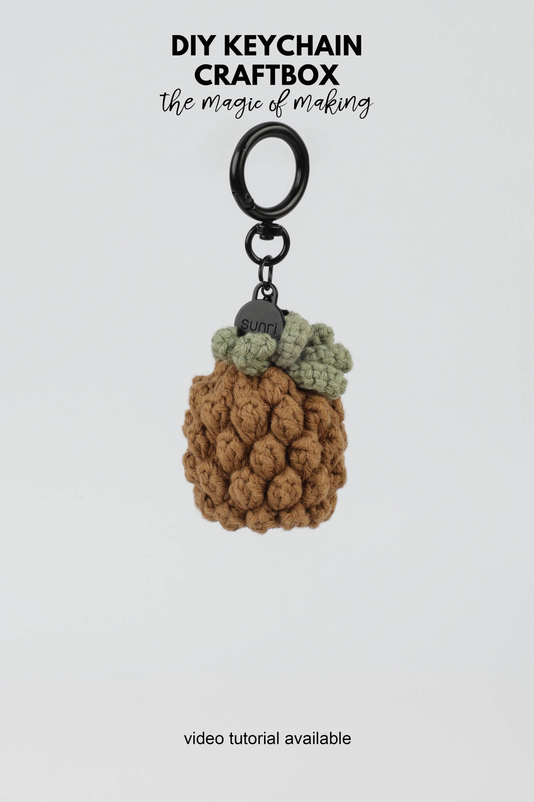 Crocheted pineapple keychain on a white background with text about DIY keychain craftbox.
