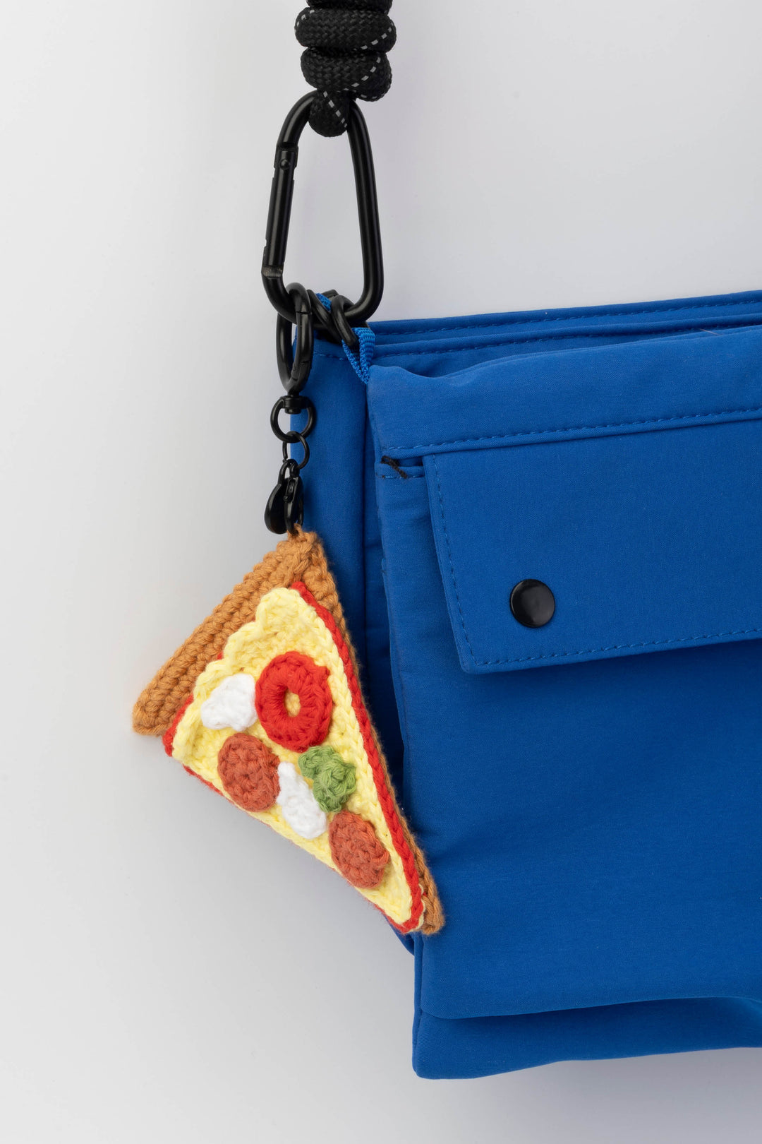 Blue bag with a pizza slice keychain on a white background