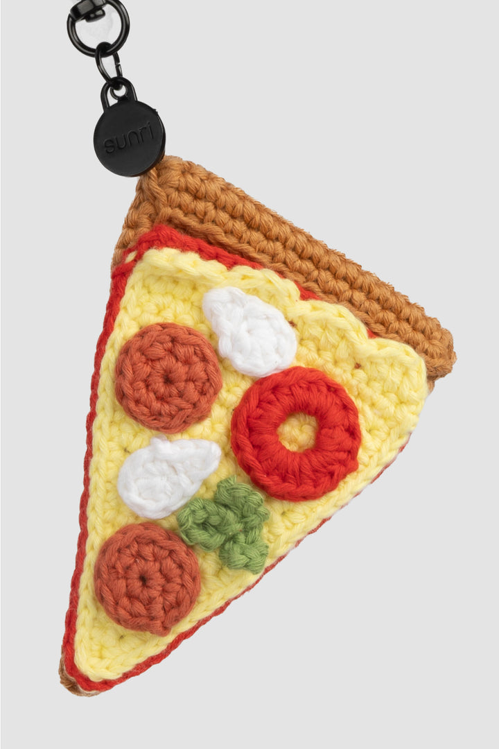 Crocheted pizza slice keychain with colorful toppings on a white background