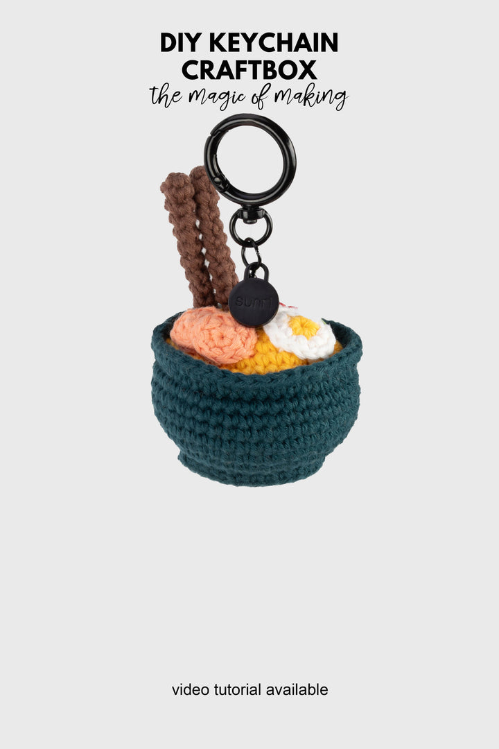 Crocheted keychain shaped like a small bowl with food items on a white background