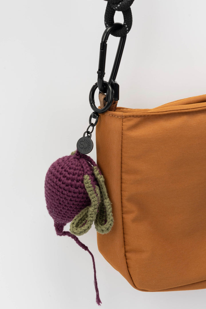 Brown bag with a beetroot crocheted keychain on a white background