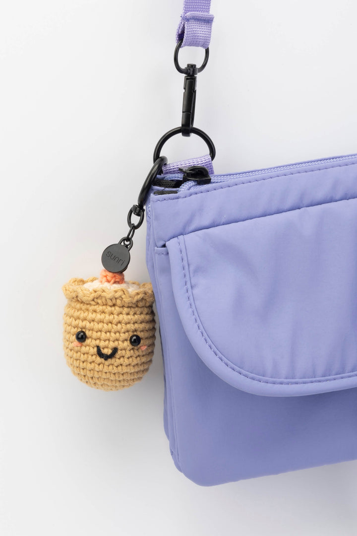 Purple bag with a small crochet sushi keychain on a white background