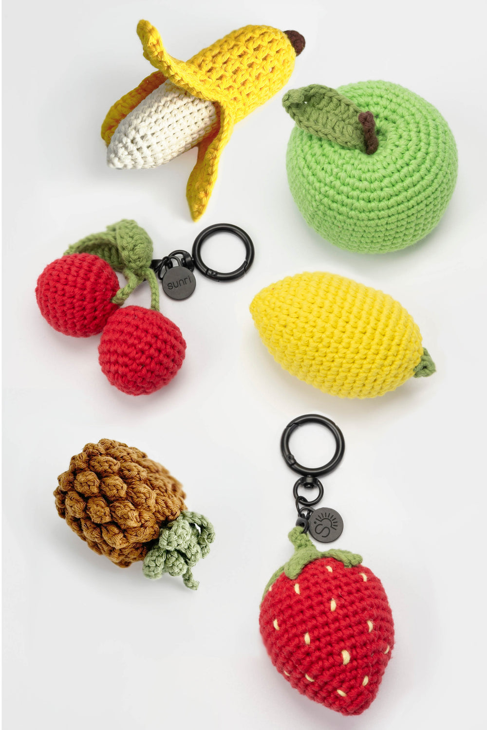 Collection of crochet fruit keychains on a white background