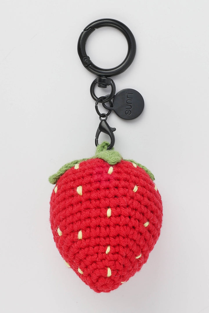 Crocheted strawberry keychain with a black metal ring on a white background