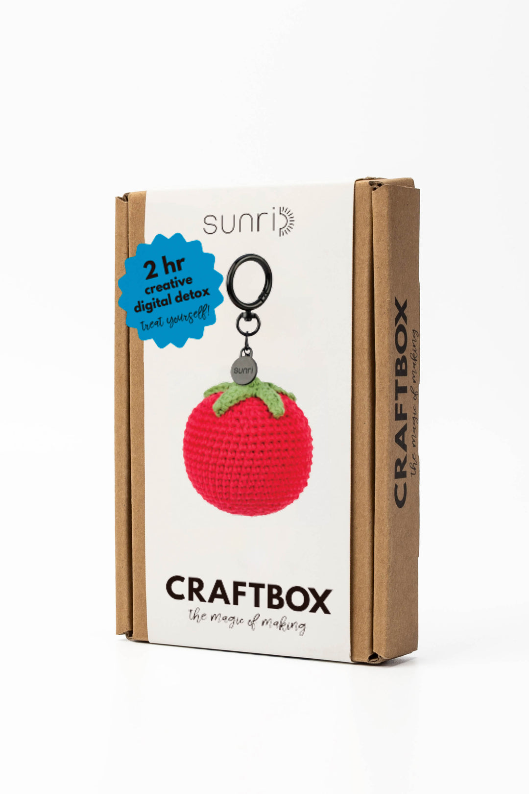 Craft box packaging with a red tomato-shaped keychain on a white background