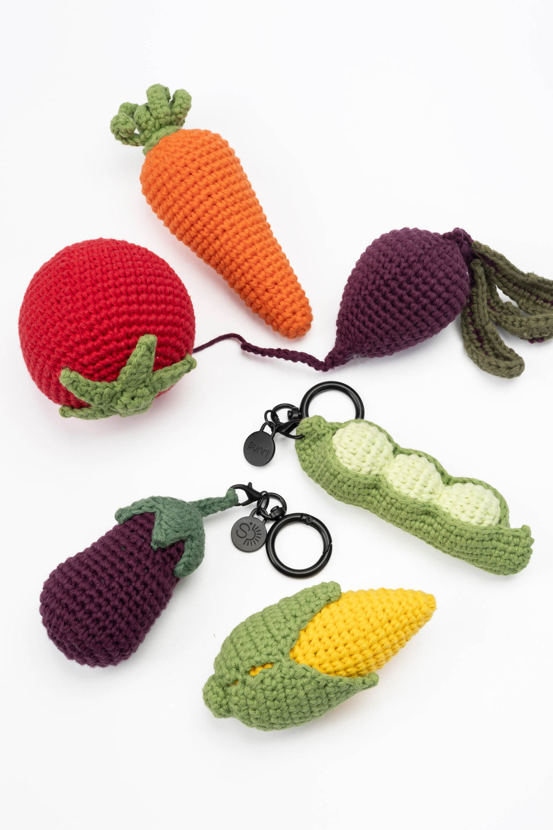 Set of crocheted vegetable keychains on a white background
