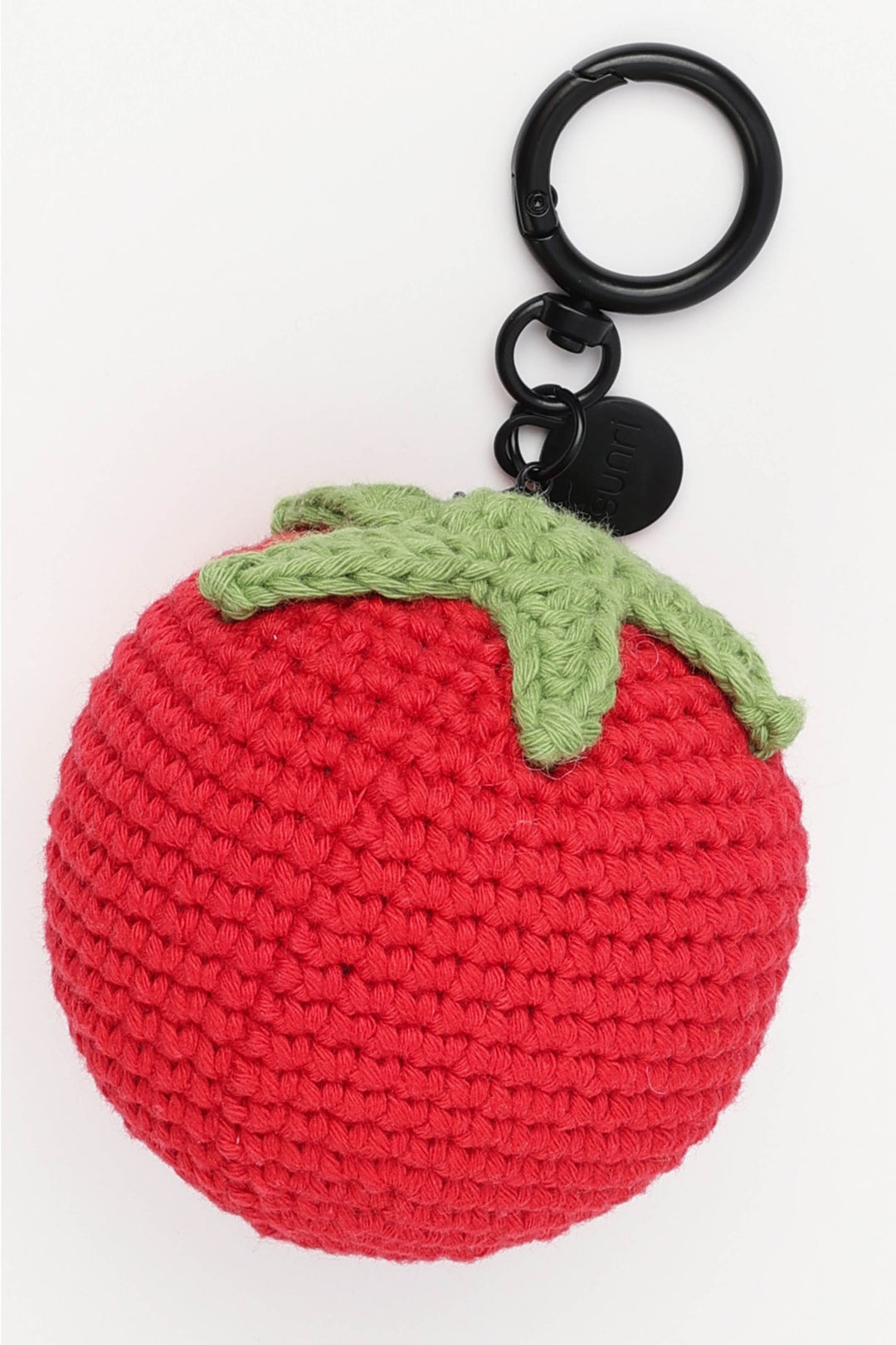 Crocheted red tomato keychain with a green stem on a white background