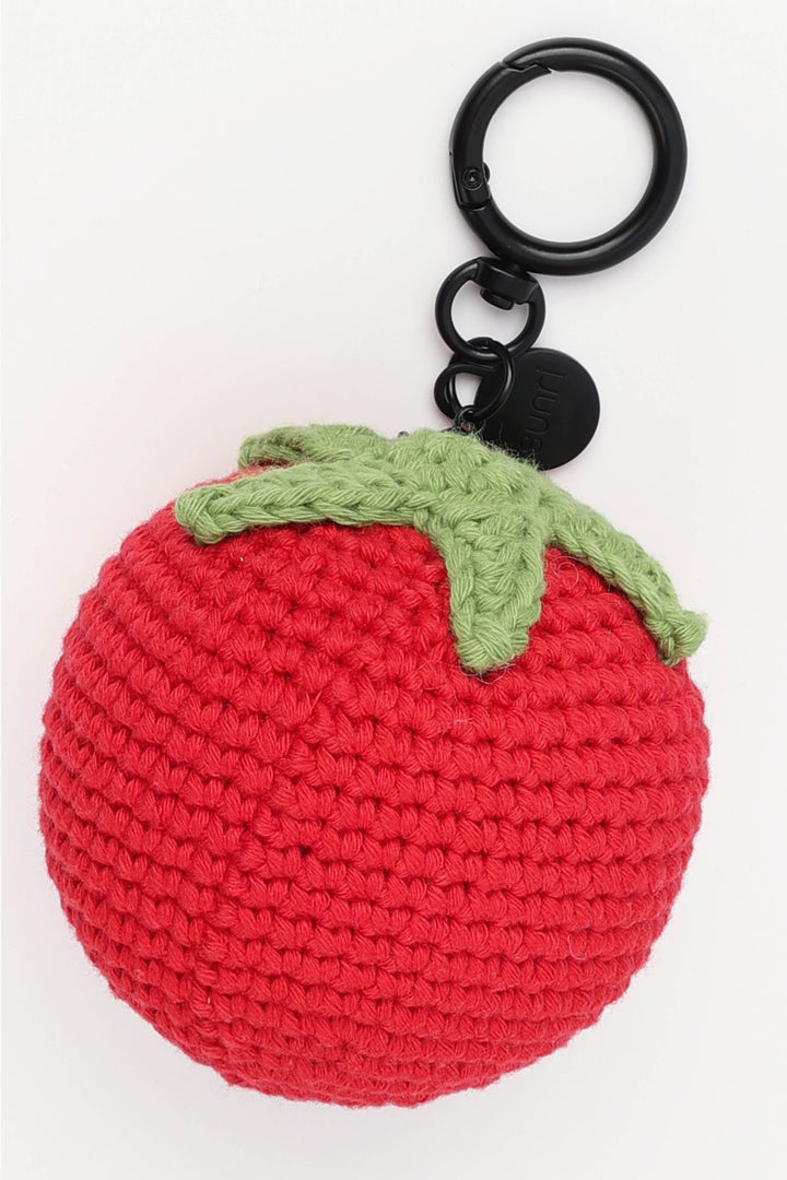 Crocheted red tomato keychain with a green stem on a white background