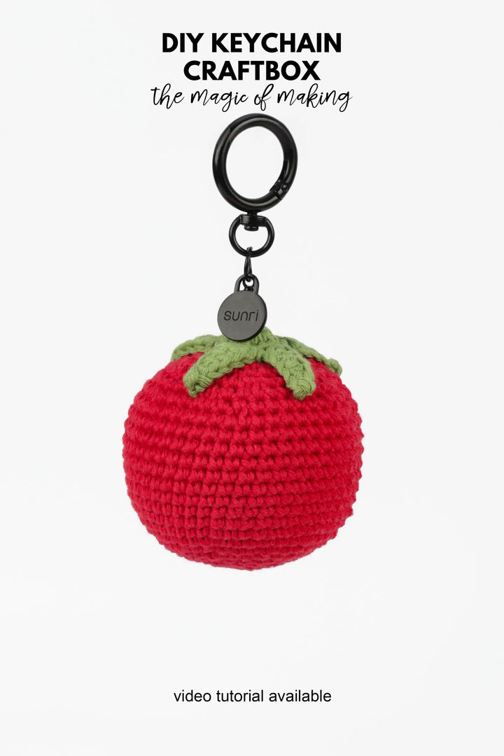 Red crocheted keychain with green stem on a white background, featuring 'DIY Keychain Craftbox' text.