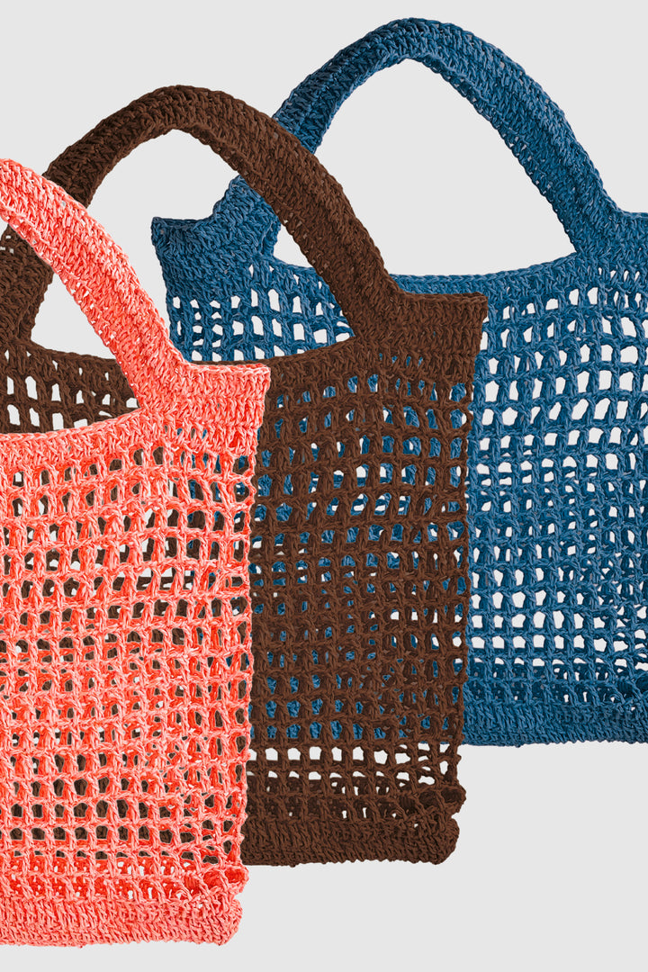 Three crochet bags in orange, brown, and blue on a light gray background