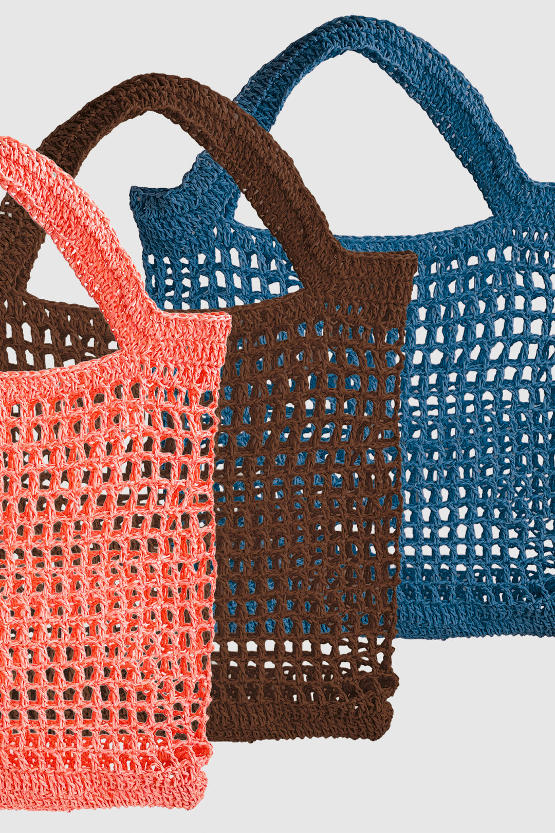 Three crochet bags in pink, brown, and blue on a light gray background