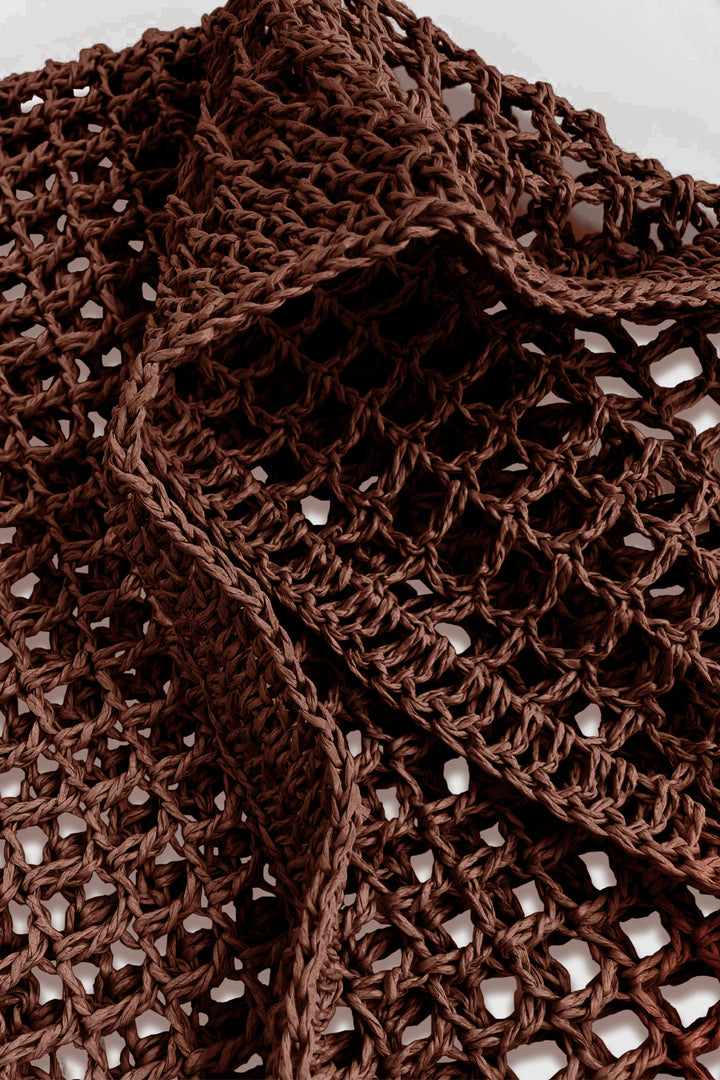Close-up of a brown crochet bag with a textured pattern.