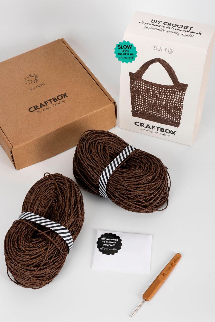Craftbox with yarn and crochet hook on a white background