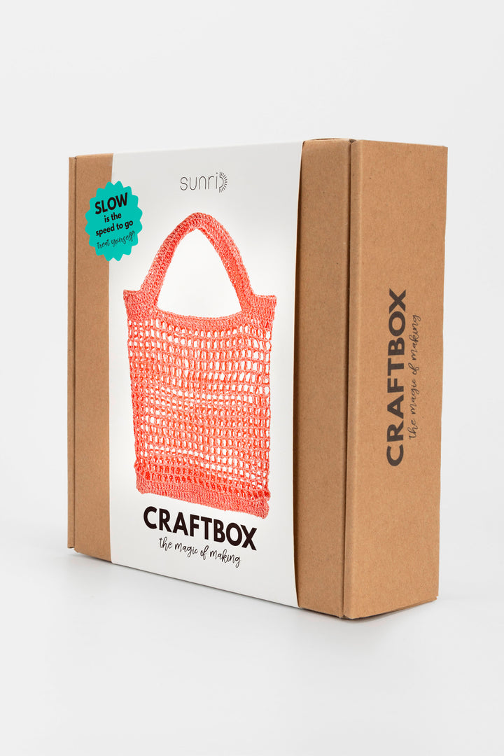 Craftbox packaging with a pink crochet bag on a white background