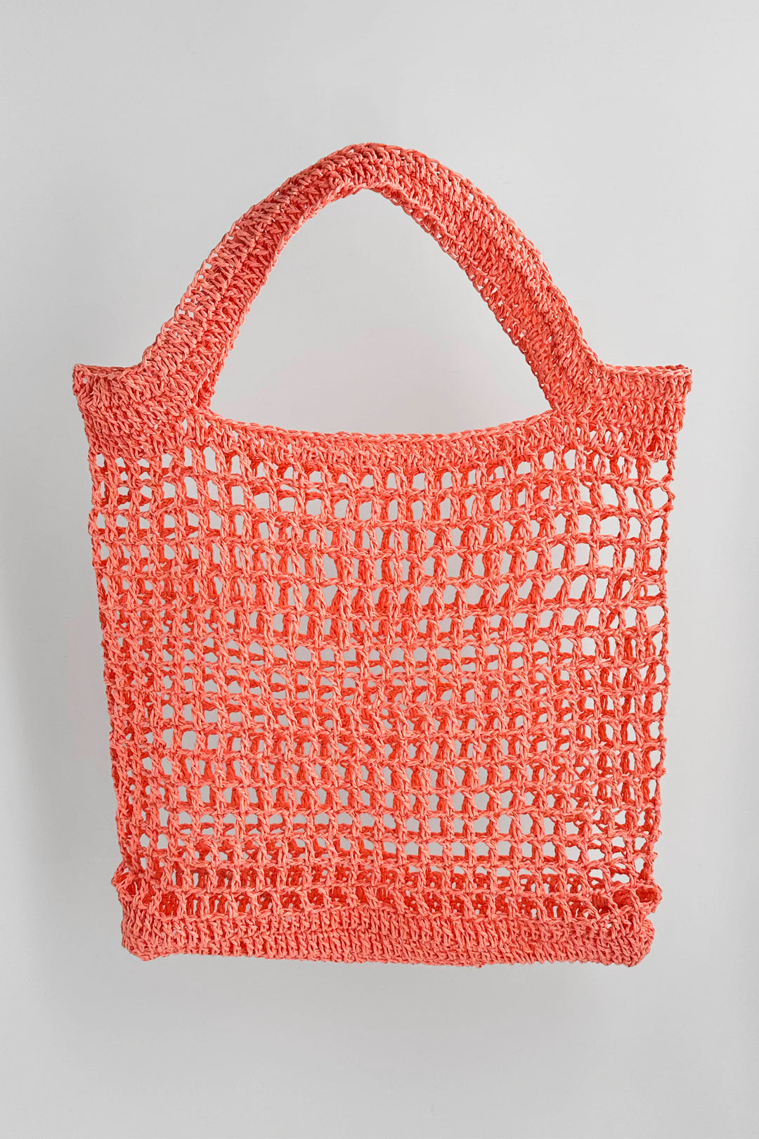 Crocheted pink bag on a light gray background