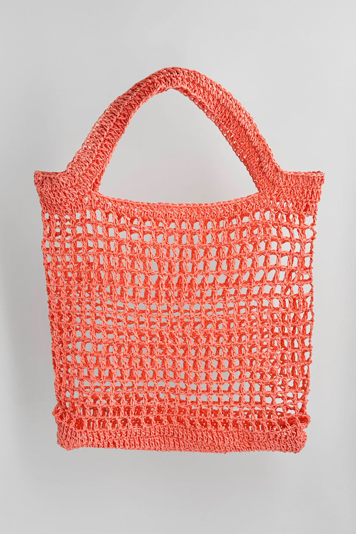 Crocheted pink bag on a light gray background