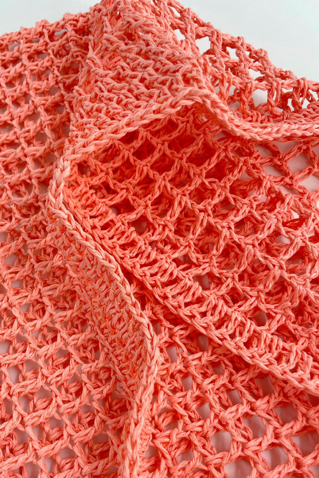 Close-up of a pink-colored knitted fabric with a textured pattern.
