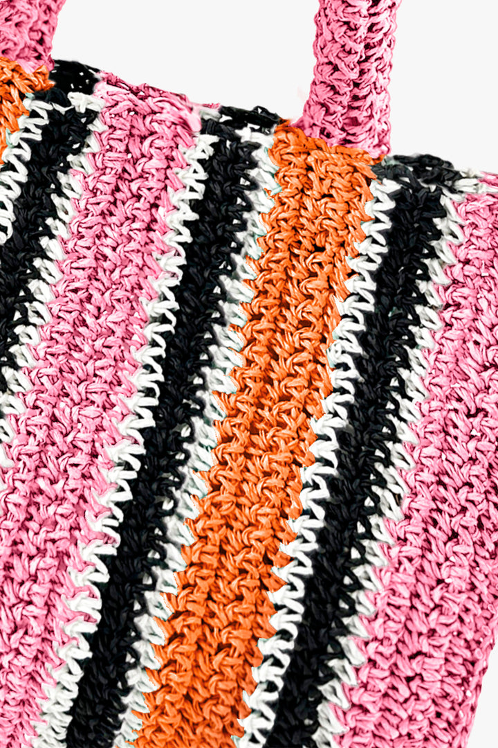 Close-up of a colorful crochet bag with pink, orange, black, and white stripes.