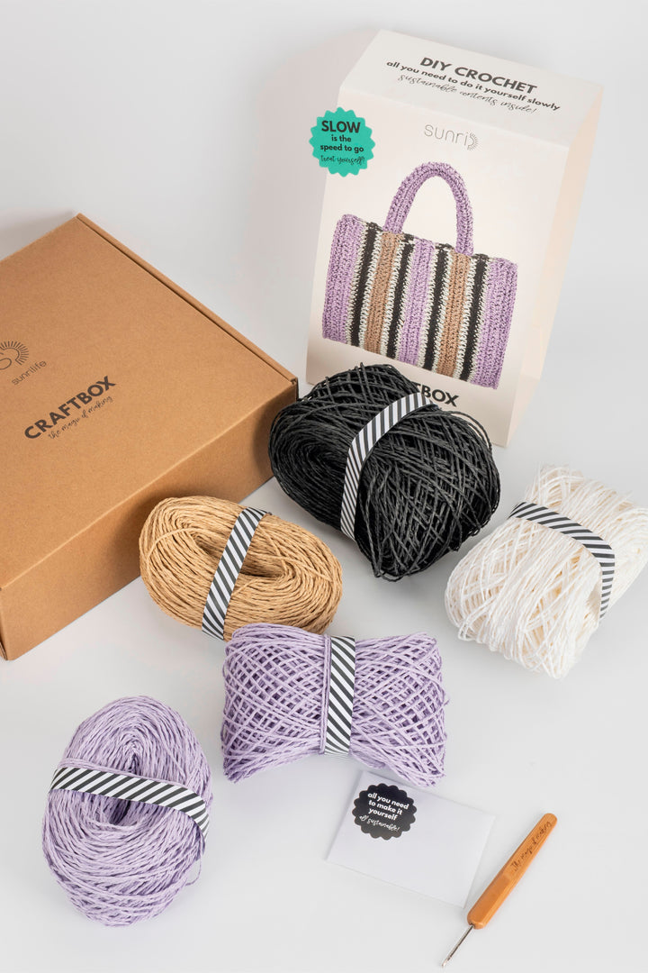 Crochet yarn set with packaging and tools on a white background