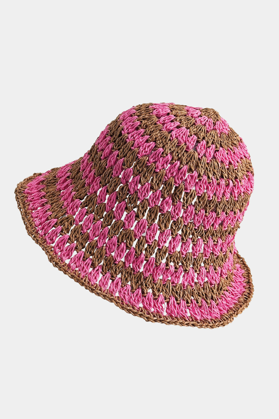 Crocheted hat with pink and brown stripes on a light gray background