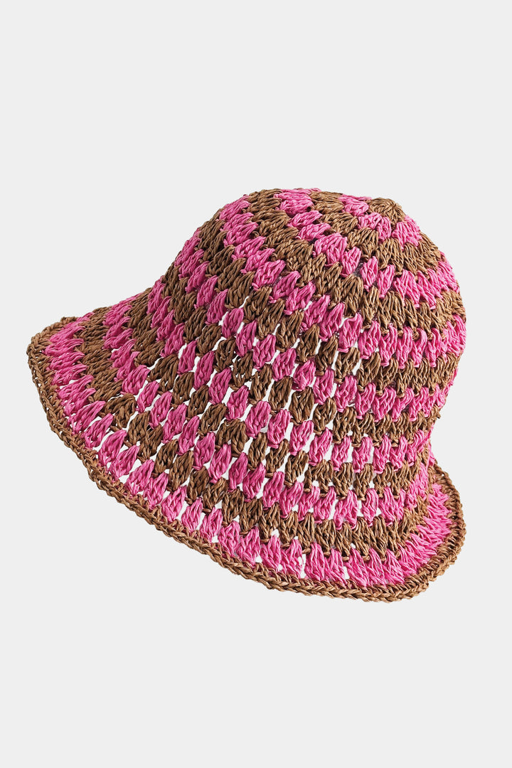 Crocheted hat with pink and brown stripes on a light gray background