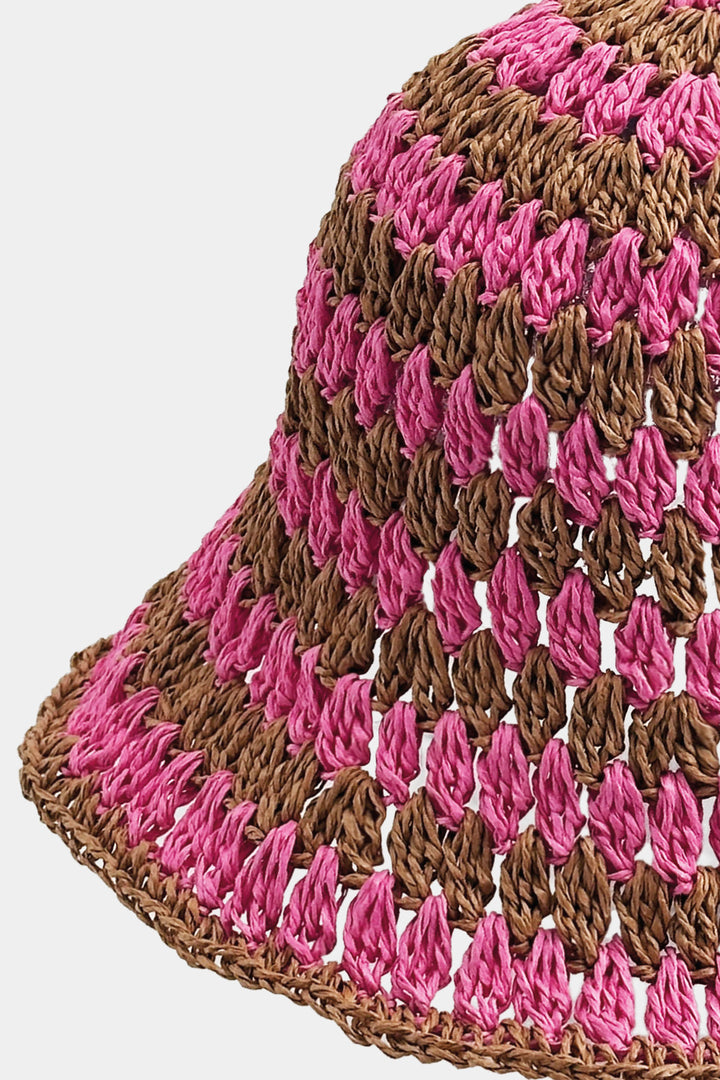 Crocheted bucket hat with pink and brown pattern on a white background