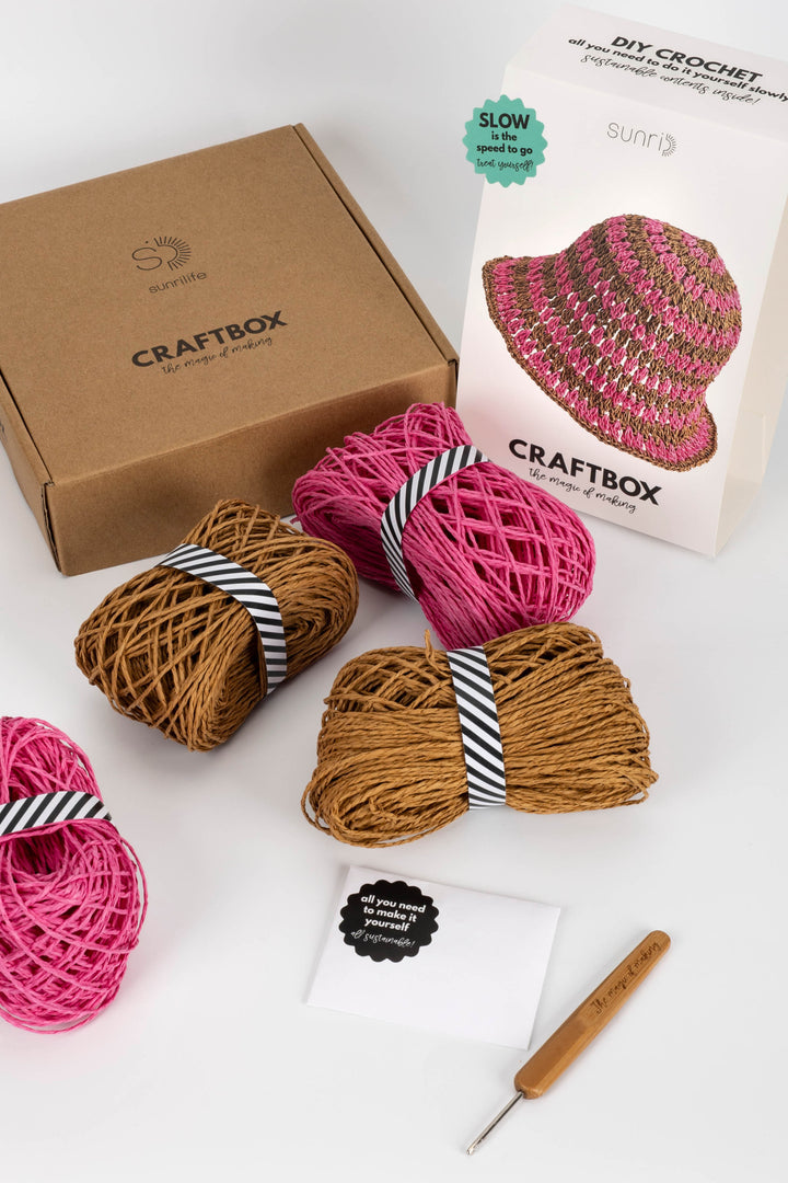 Craftbox with yarn and crochet hook on a white background