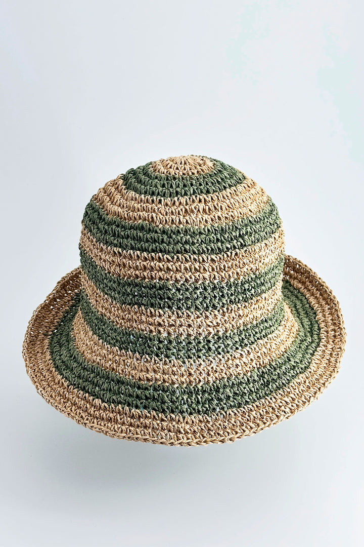 Striped straw hat with green and beige pattern on a light gray background