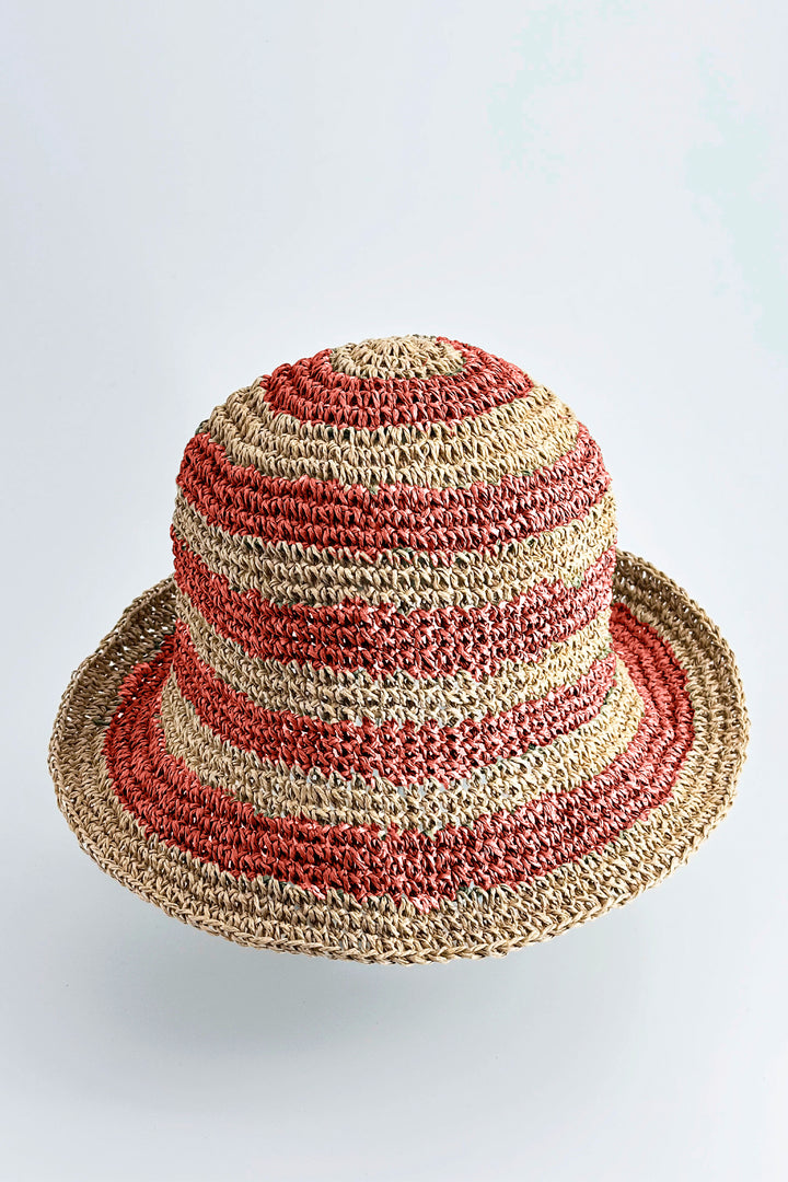 Striped straw hat with red and beige pattern on a white background