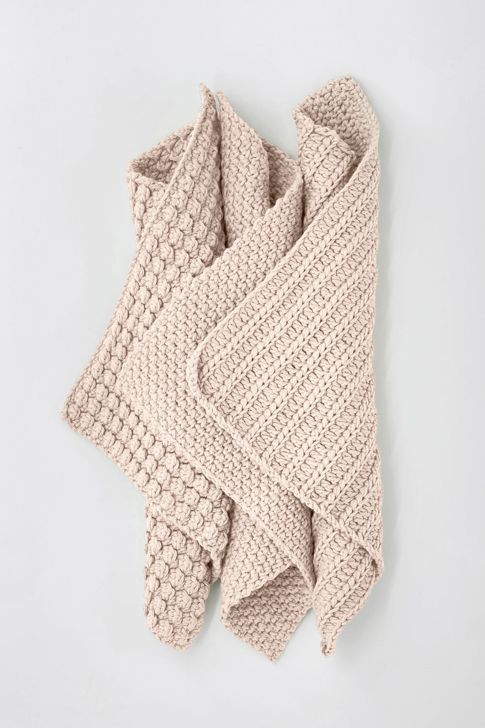 Knitted beige towels on a light gray background