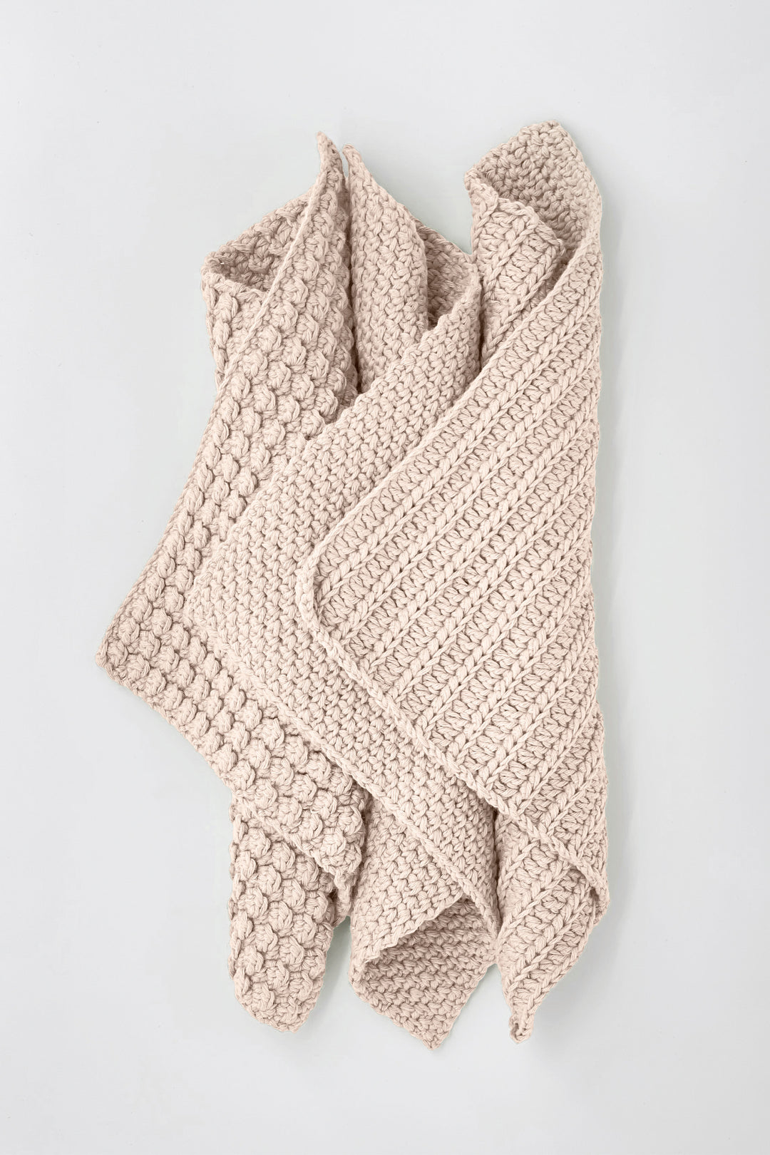 Knitted beige towels on a light gray background