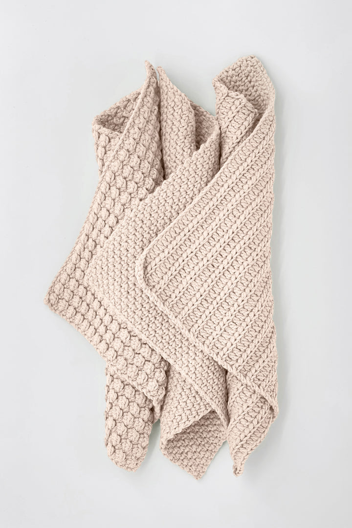 Knitted beige towels on a light gray background