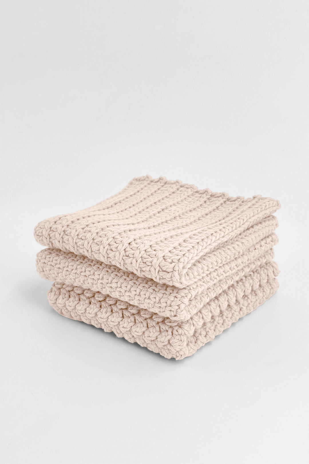 Stack of beige  textured towels on a light gray background